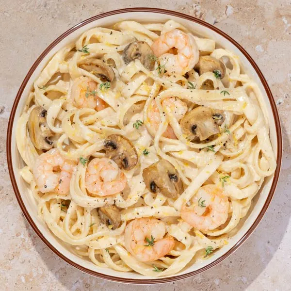 Fetuccinne al limón con langostinos y champiñones