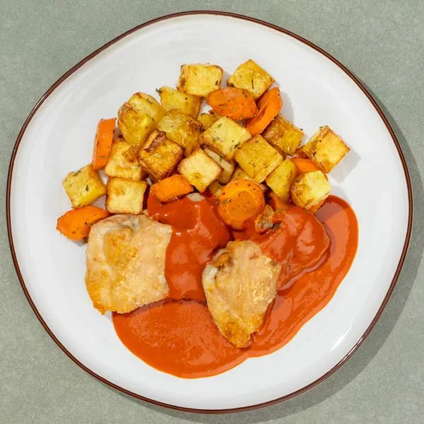 Pollo con salsa brava, patatas y zanahorias